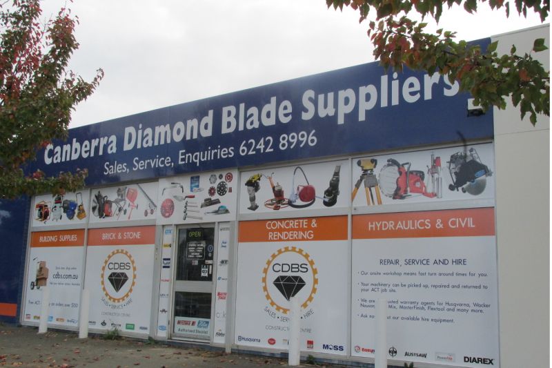 Exterior view of Canberra Diamond Blade Suppliers storefront, showcasing a variety of construction equipment and services including building supplies, concrete and rendering, hydraulics, and civil repair services. The shop offers machinery repair, service, and hire, with a contact number and website details visible.